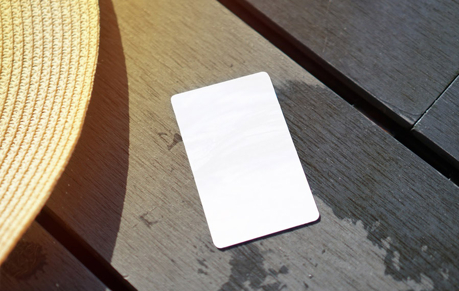 Don't forget your pool pass to to take a refreshing swim at Sylo Apartments. Summer hat and key card on a deck floor.