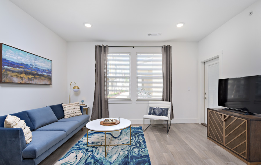 Install blackout curtains to keep your home several degrees cooler. Modern living room on a sunny day.