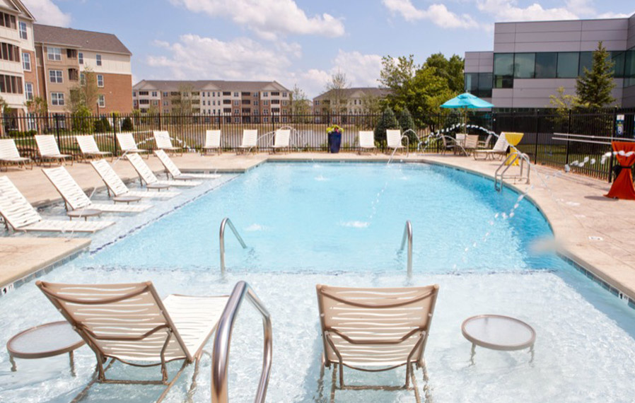 A beautiful blue pool enhances your apartment experience in Zionsville. Lake side pool on a sunny day.